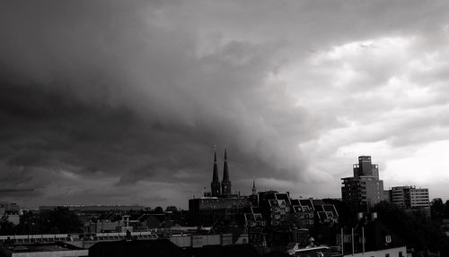 View of cityscape against cloudy sky