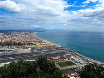 Aerial view of town by sea against sky