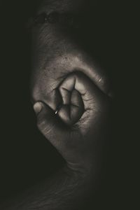 Close-up of man hand over black background