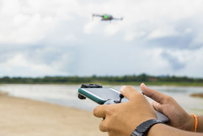 Midsection of man photographing against sky