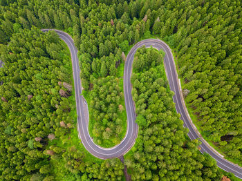 Winding road from high mountain pass, in spring time. aerial view by drone. romania