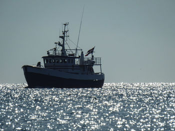 Ship sailing in sea against clear sky