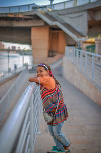 Man standing on footbridge in city