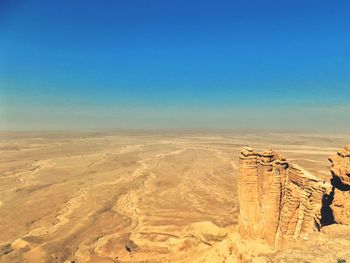 Aerial view of desert against clear blue sky