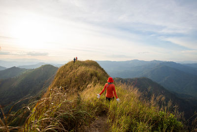 Rear view of people on mountain against sky