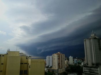 Low angle view of modern buildings against cloudy sky