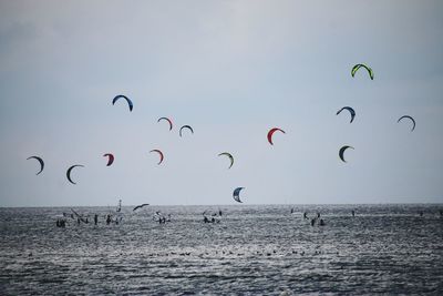 People kiteboarding in sea against clear sky