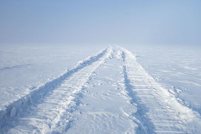 Snow covered field against sky