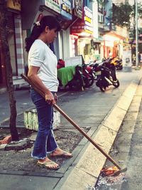 Side view of man standing on street in city