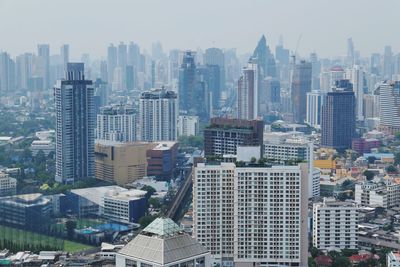 Aerial view of buildings in city against sky