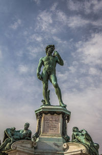 Low angle view of angel statue against cloudy sky