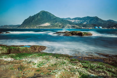 Scenic view of sea and mountains against sky