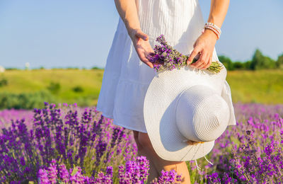 Midsection of woman holding flowers