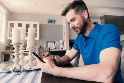 Young man using mobile phone at home