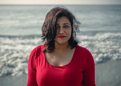 Portrait of beautiful young woman standing on beach