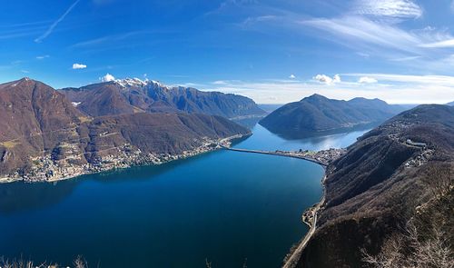 High angle view of lake and mountains against blue sky