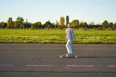 Rear view of woman walking on road