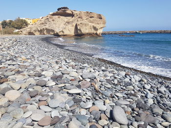 Rocks on beach against clear sky