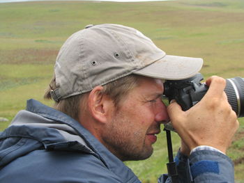Side view of mature man photographing with camera