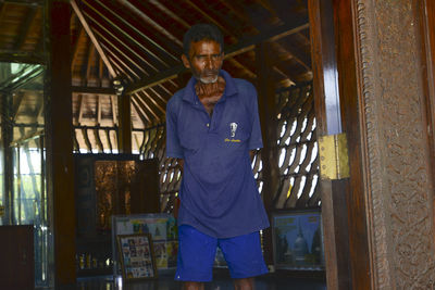 Portrait of smiling man standing in corridor