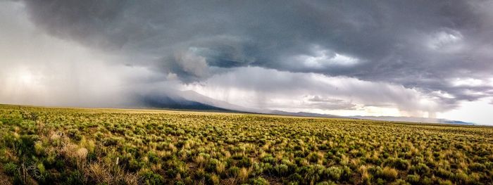 Scenic view of field against cloudy sky