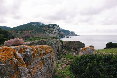 Rock formations by sea against sky