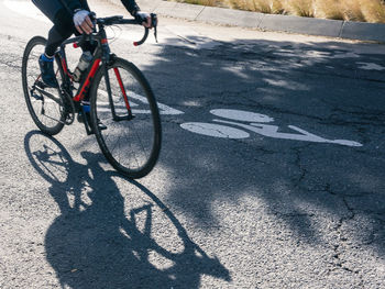 Low section of man riding bicycle on street