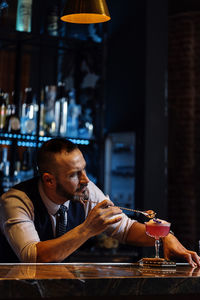 Man holding drink at table