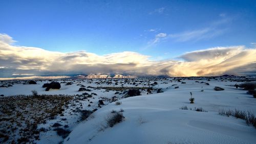 Scenic view of snow covered land against sky