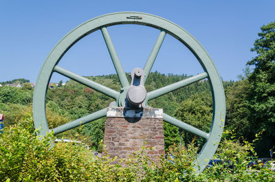 Close-up of metal structure on field against clear sky