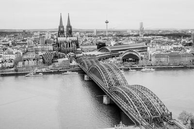 Bridge over river in city against sky