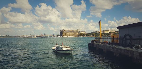 Boats in sea against buildings in city