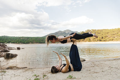 Young female friends doing acroyoga