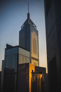 Low angle view of buildings against clear sky at dusk