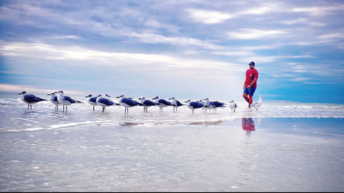 Rear view of men walking on land against sky