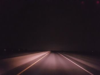 Empty road against sky at night