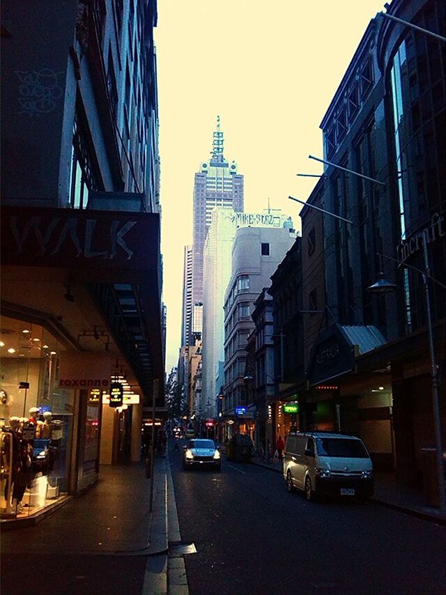 building exterior, architecture, built structure, city, transportation, car, street, land vehicle, city street, the way forward, city life, road, mode of transport, building, incidental people, residential building, diminishing perspective, sky, illuminated, clear sky