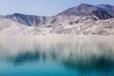 Scenic view of lake and snowcapped mountains against sky