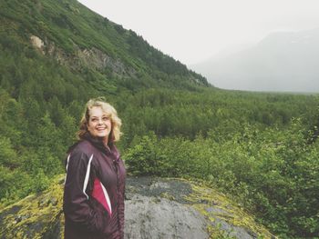 Smiling young woman standing on landscape