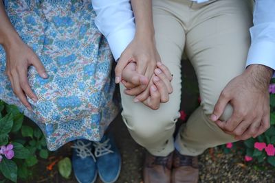 Midsection of couple holding hands