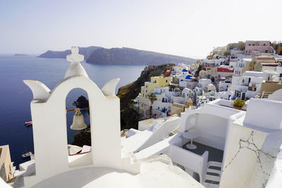 Close-up of bell tower of a church in oia village with cozy picturesque sight, santorini, greece