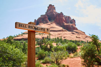 Close-up of signboard on mountain against sky