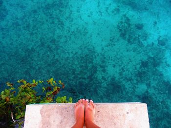 Low section of woman relaxing in swimming pool