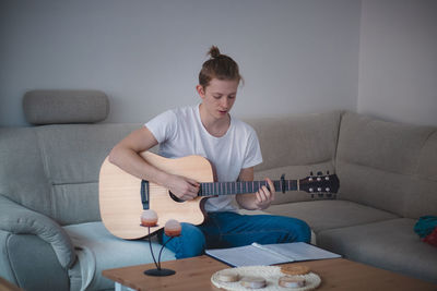 Man playing guitar at home