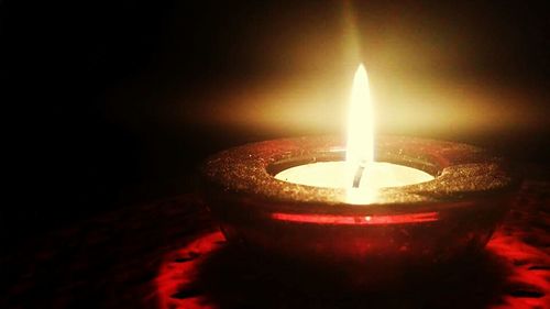 Close-up of lit candle in dark room