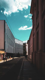 People on street amidst buildings against sky