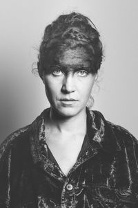 Portrait of woman with face paint against gray background