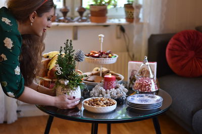 Rear view of woman holding food on table