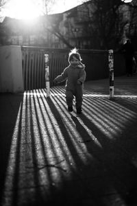 Rear view of boy standing by tree