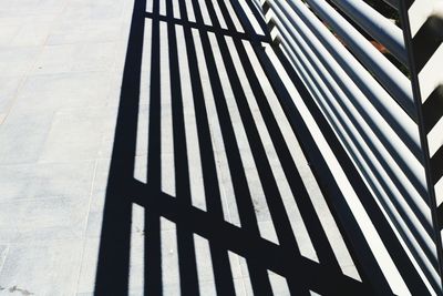 High angle view of railing and shadow on fence